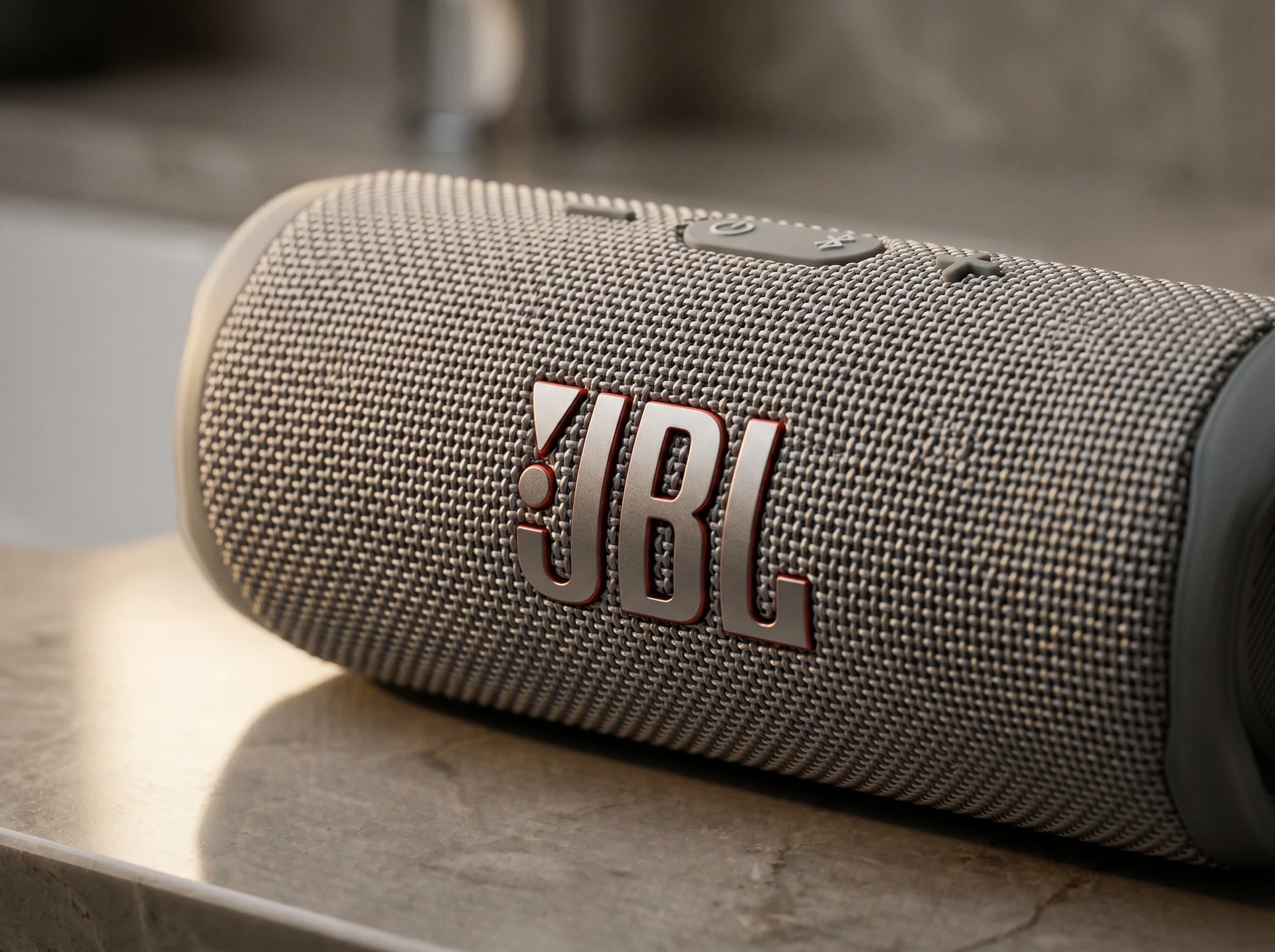 JBL Flip 6 серый — внешний вид колонки в интерьере, цилиндрический корпус из пластика и ткани